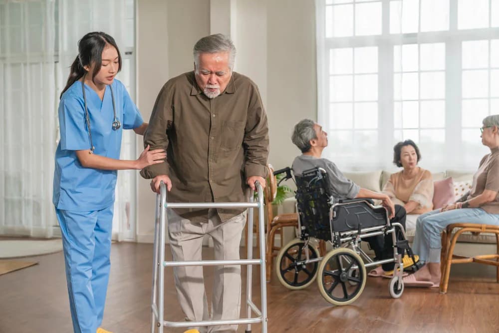 A therapist supporting a client walking with a frame