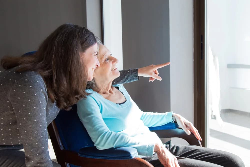 A respite caregiver with a client by the window